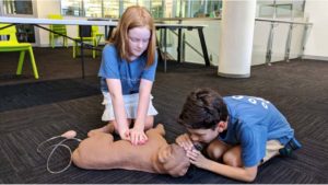 Kids practicing performing CPR on a dog